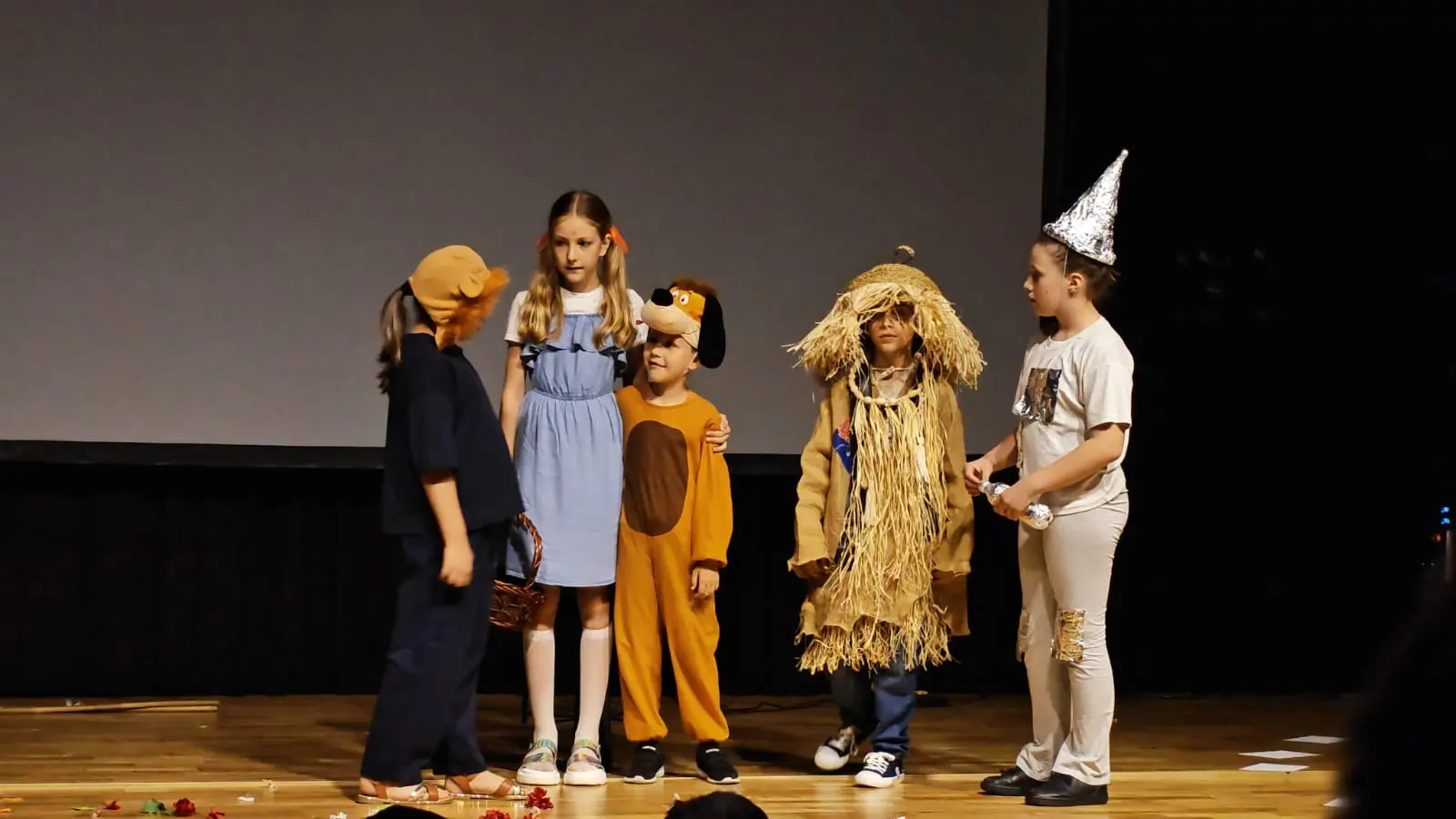 Elevi în costume de sperietoare, leu și Dorothy, într-o scenă de grup